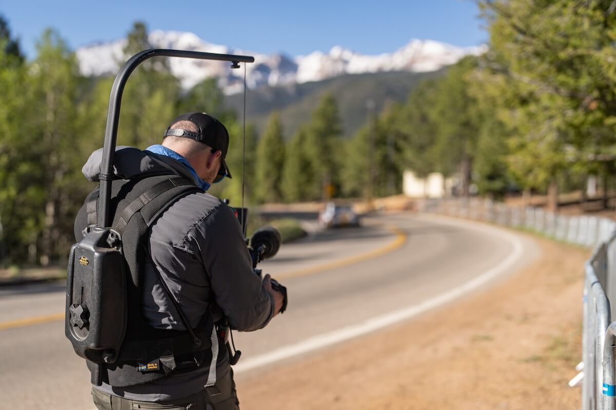 Cameraman filming on Pikes Peak. Remote video production with fast footage transfer using MASV file delivery.